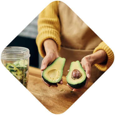 A woman cutting an avocado in half