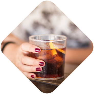 Woman's hand holding glass of fizzy drink